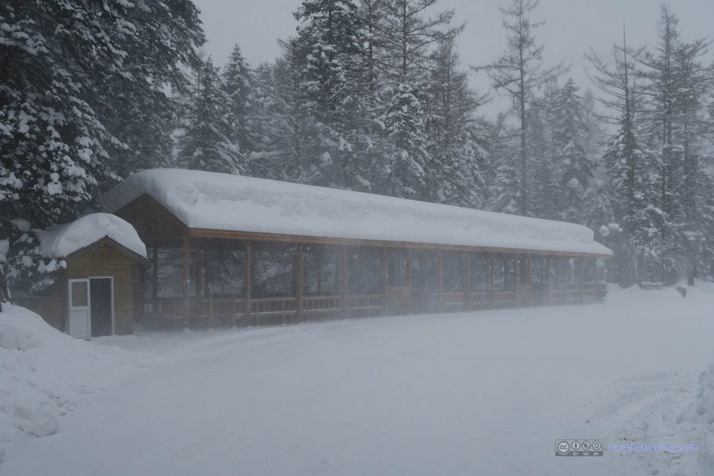 长白山大峡谷的停车场，屋檐上的雪在风吹过之后向漫天纷飞